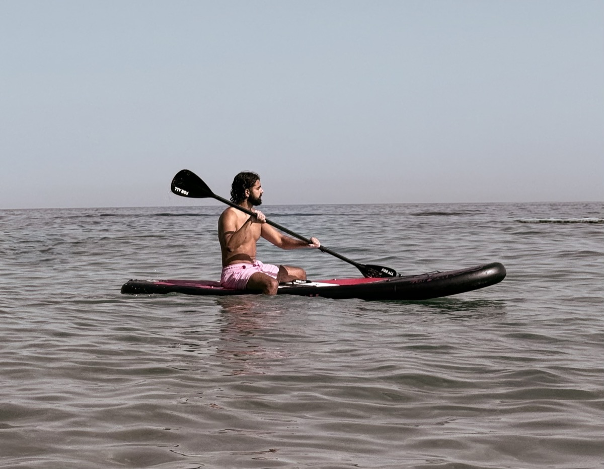 Panos Michelakis paddling a SUP board on calm water off the coast